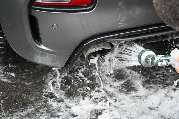 Vehicle detailing and car wash supplies being used for automotive care