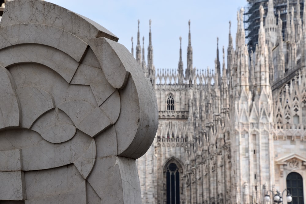 a stone sculpture in front of a cathedral