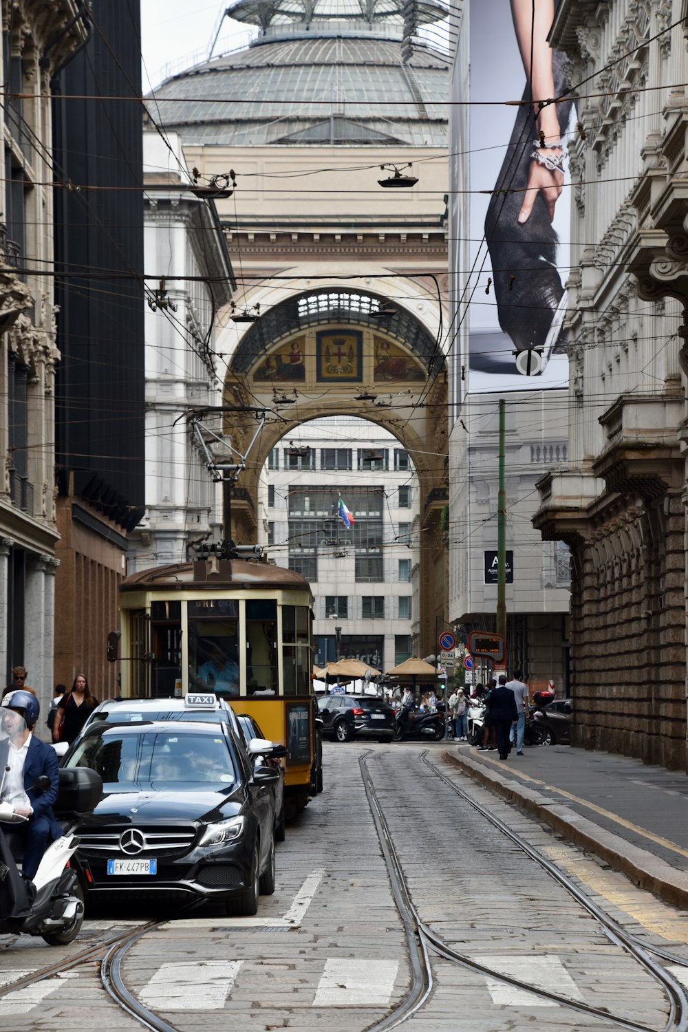 a street scene with a tram and a car