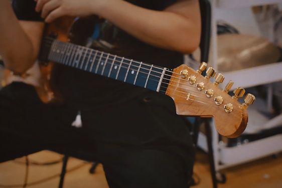 A passionate music teacher guiding a student through a guitar lesson in a cozy studio.