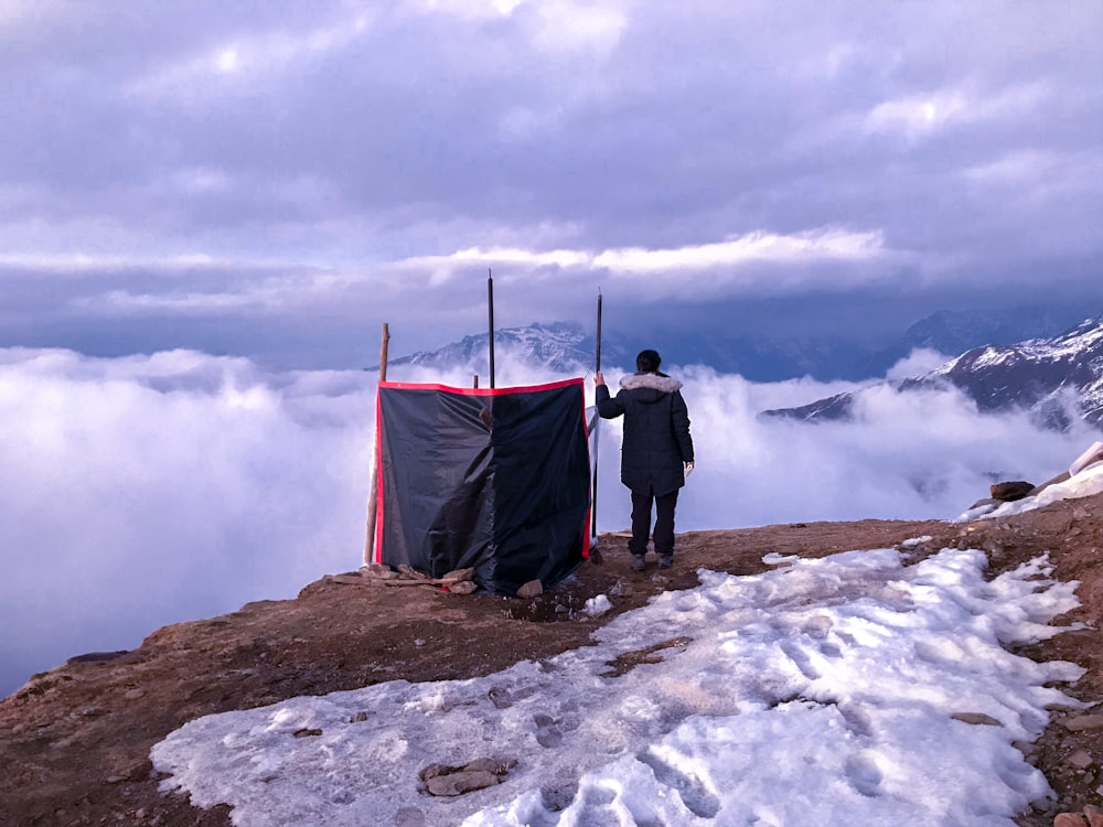 a man standing on top of a snow covered mountain