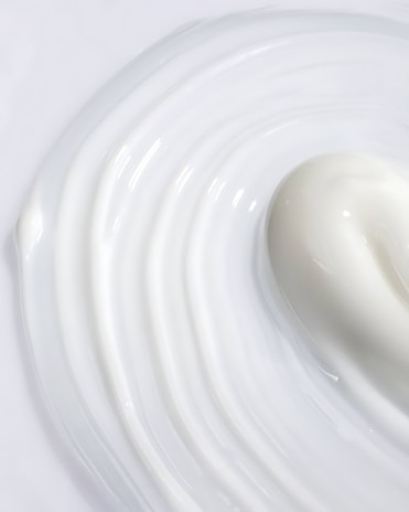 A creamy milk paleta melting slightly, showing its smooth texture and natural color.