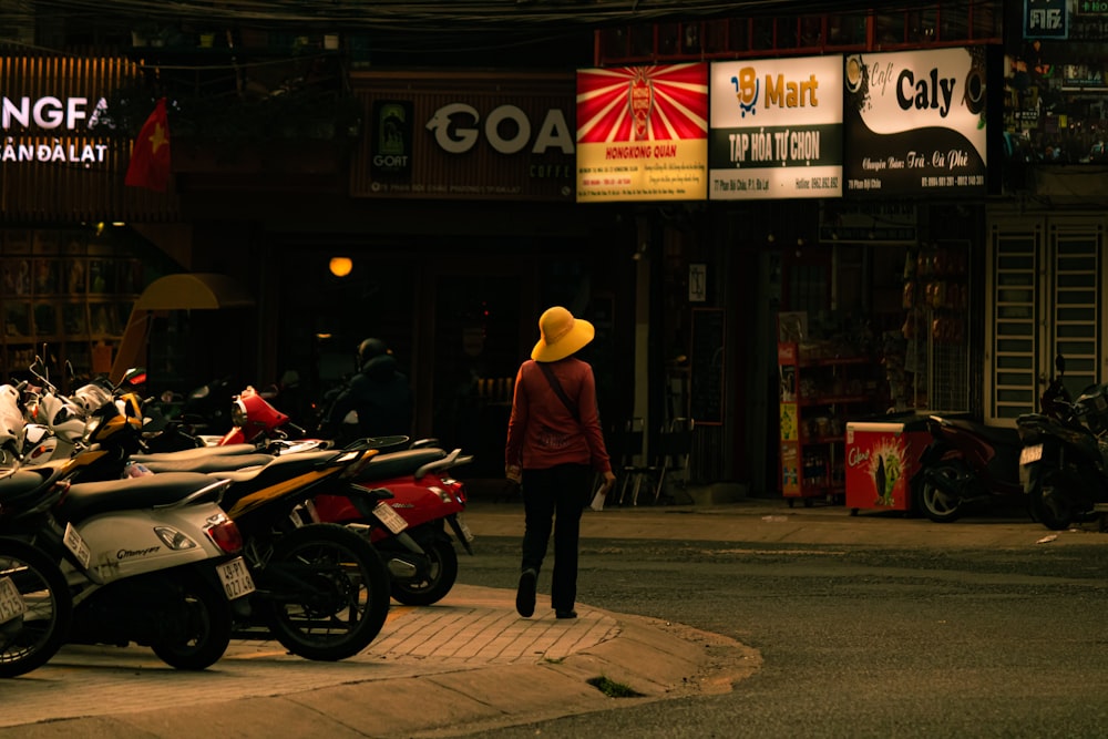 a woman in a yellow hat standing next to a row of motorcycles