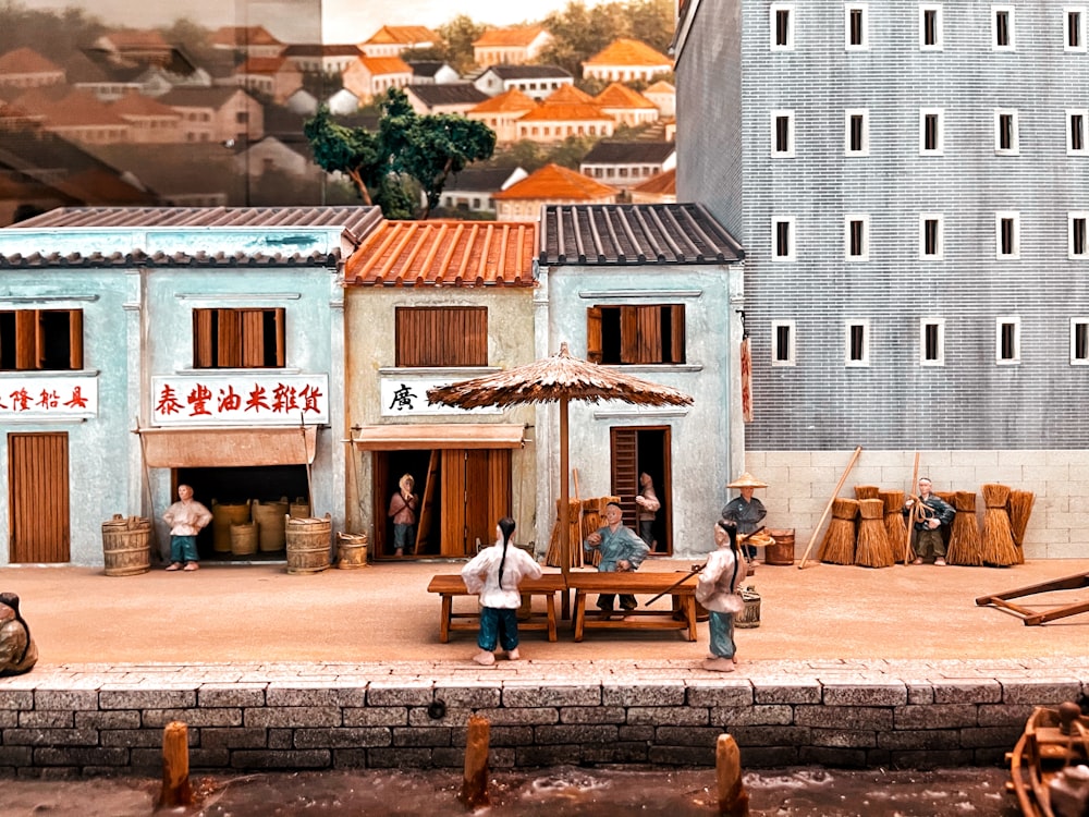 a group of people standing around a model of a town