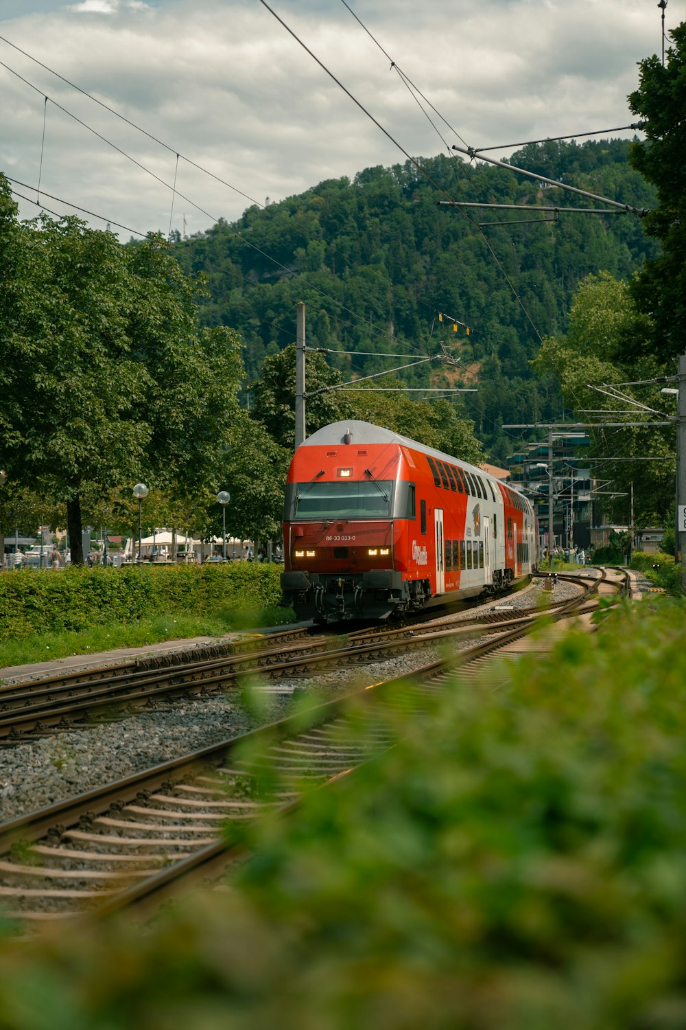 a red and white train traveling down train tracks