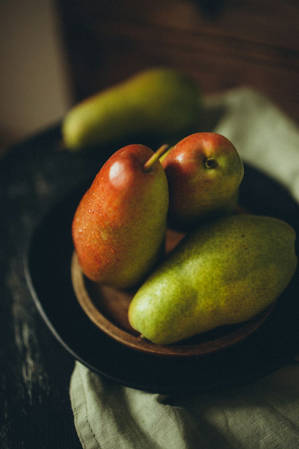 a bowl of pears and pears on a table