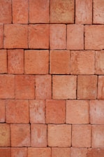 Close-up of stacked red clay bricks showing texture and uniformity.