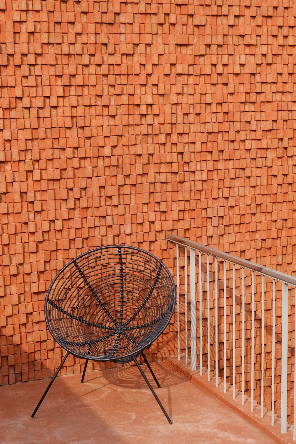 a black basket sitting on top of a metal stand