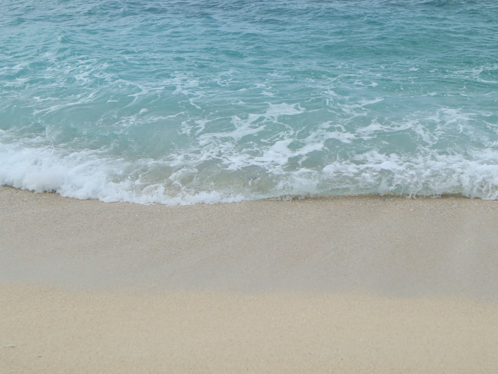 a beach with a wave coming in to the shore