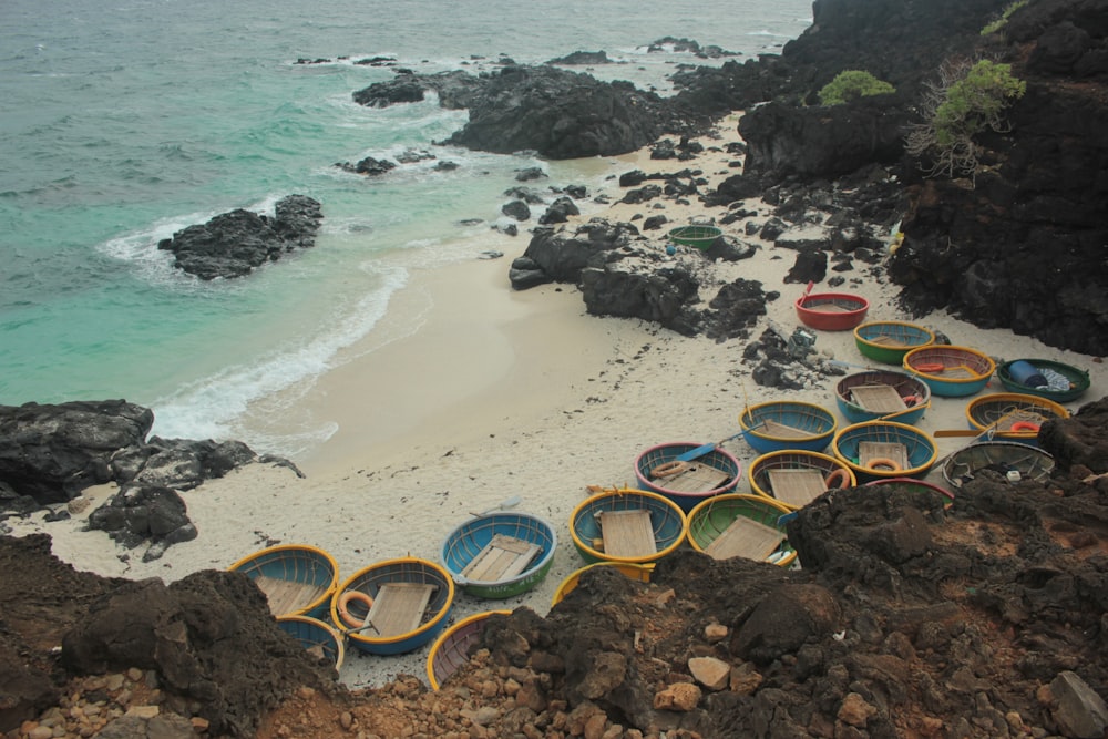 a group of boats sitting on top of a beach next to the ocean