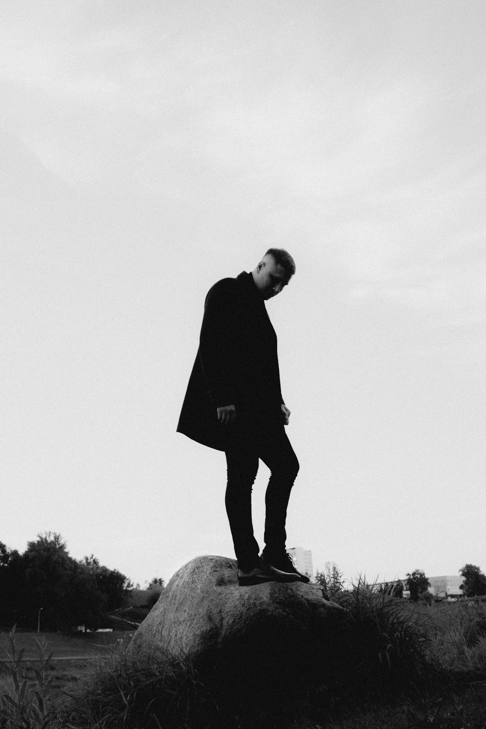 Un homme debout au sommet d’un gros rocher