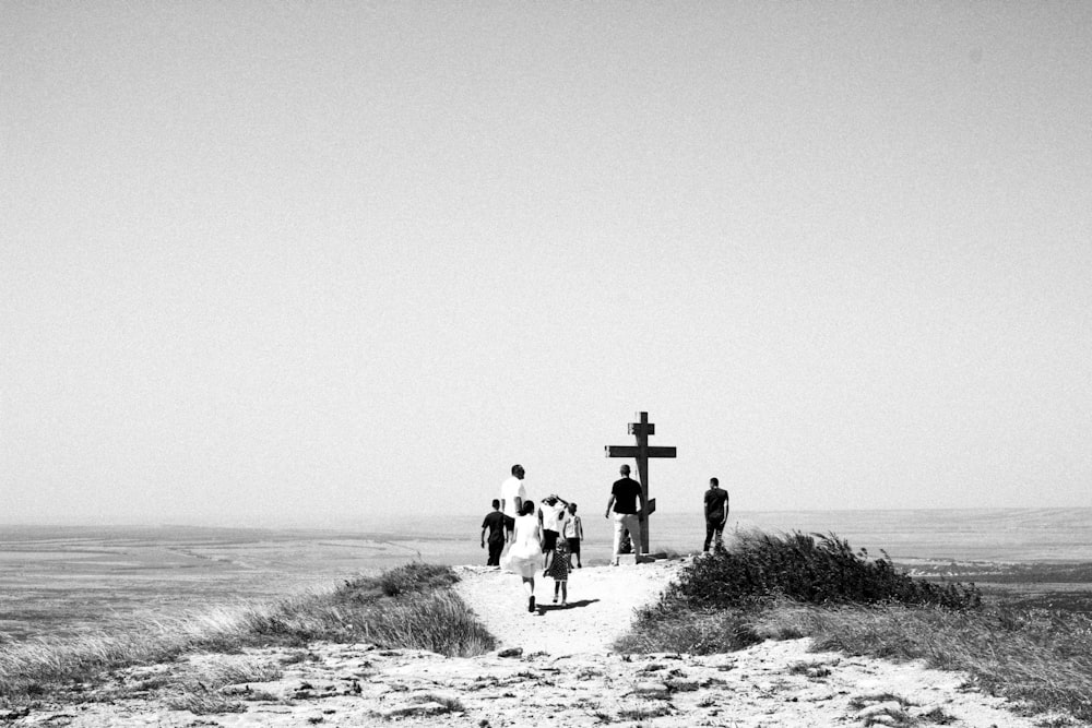 a group of people standing on top of a sandy beach