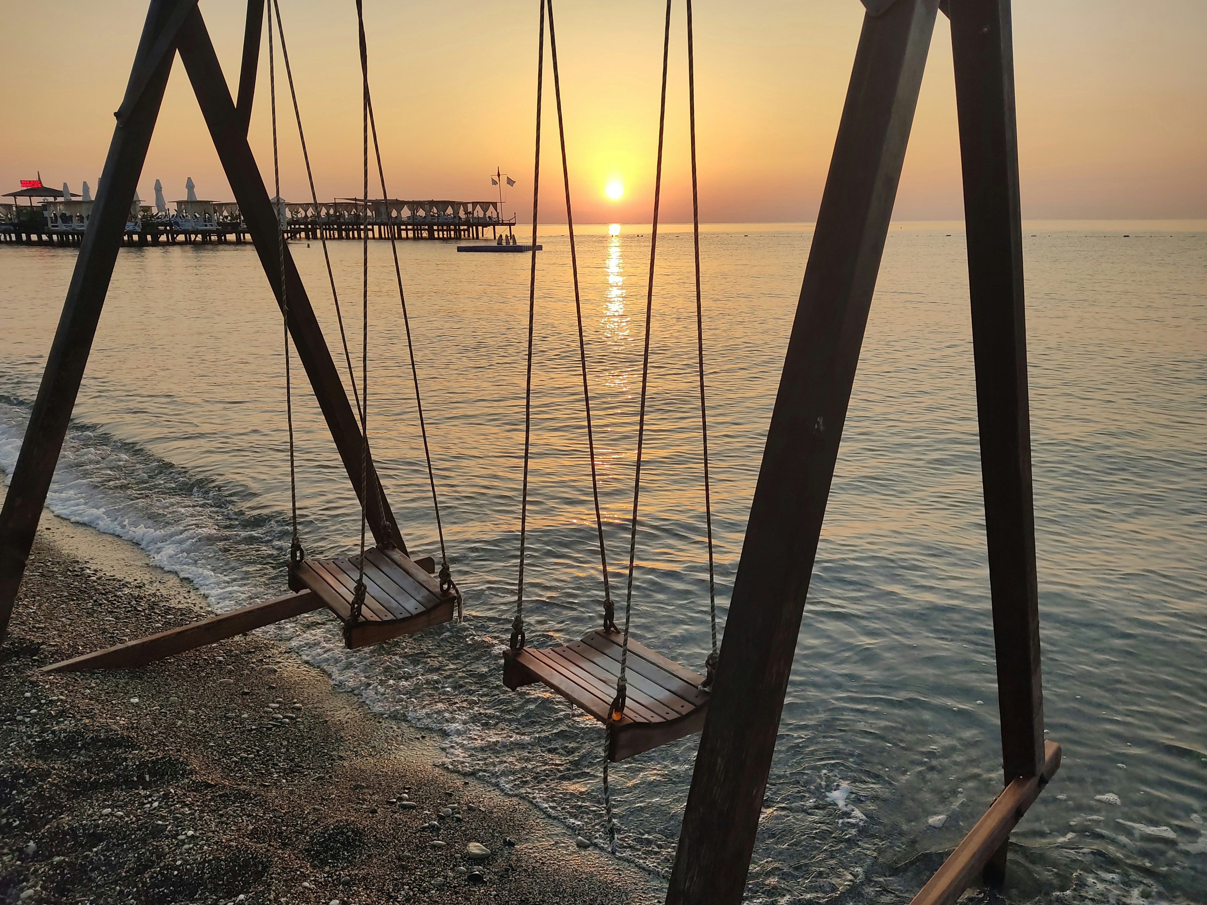 a couple of swings sitting on top of a beach