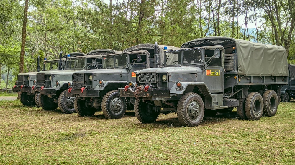 Eine Gruppe von Militärlastwagen, die nebeneinander geparkt sind