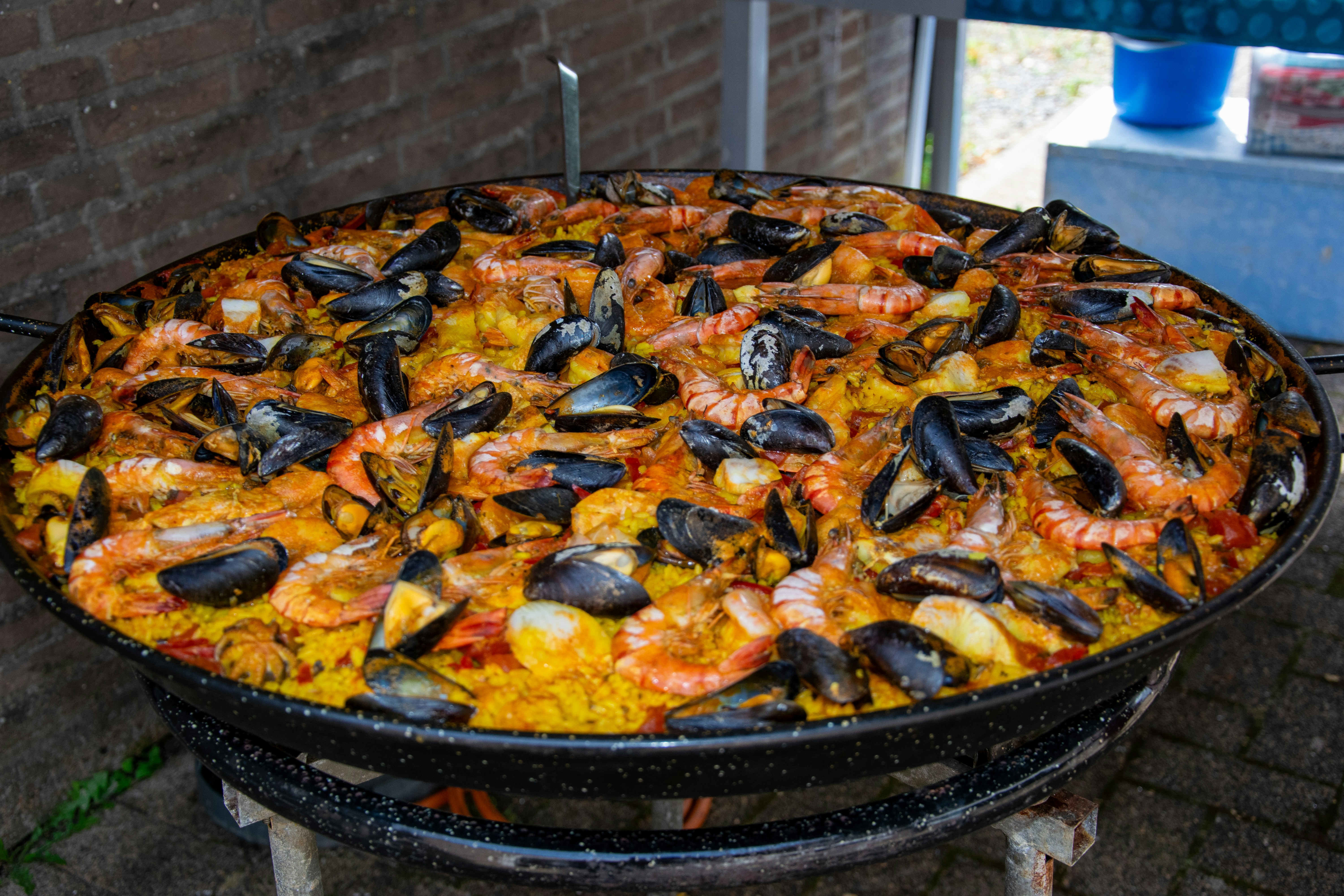 a large paella of seafood and rice on a grill