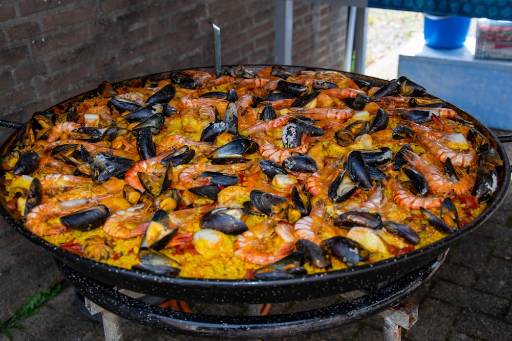 a large paella of seafood and rice on a grill