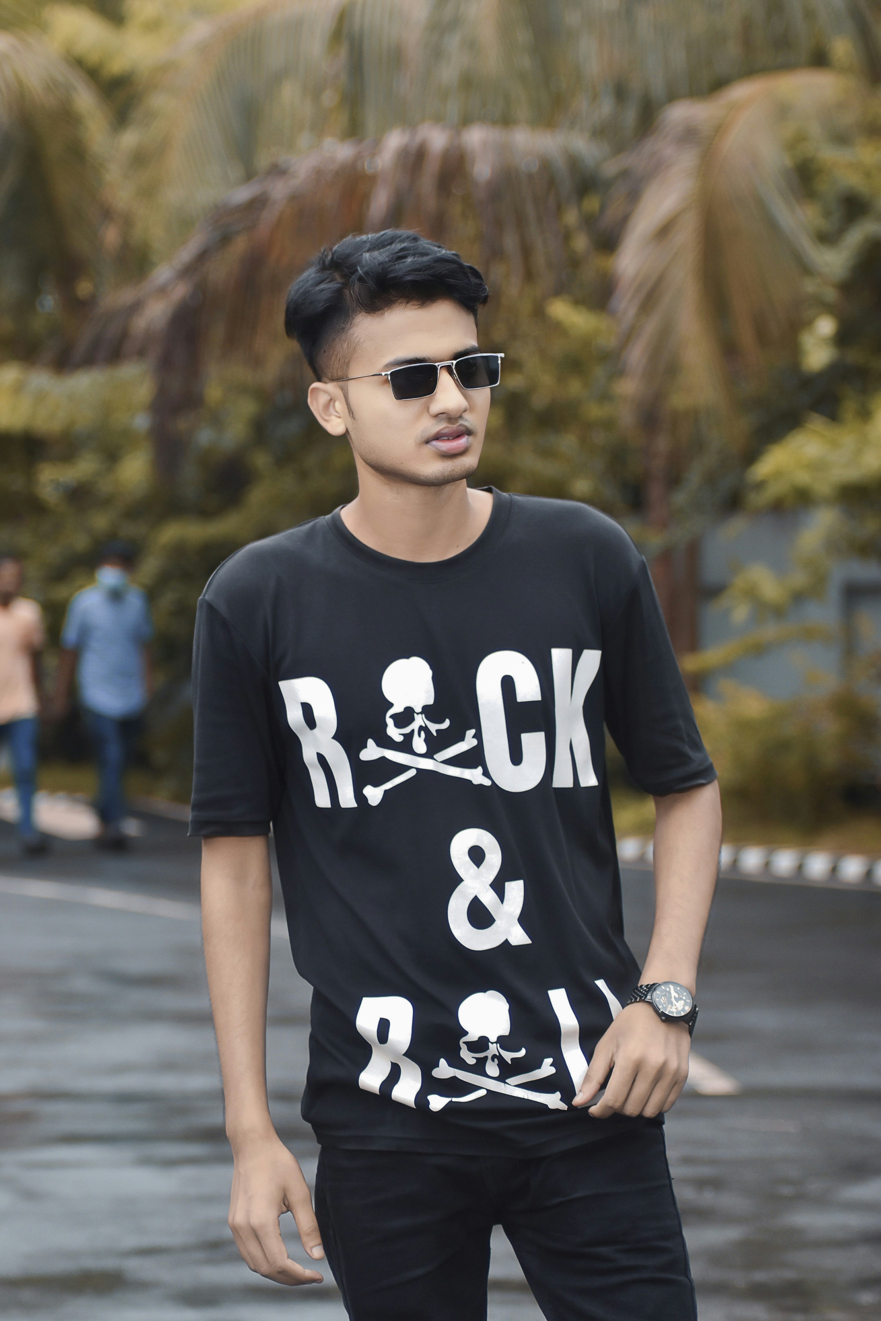 Pria muda dengan kaos rock and roll dan kacamata hitam.