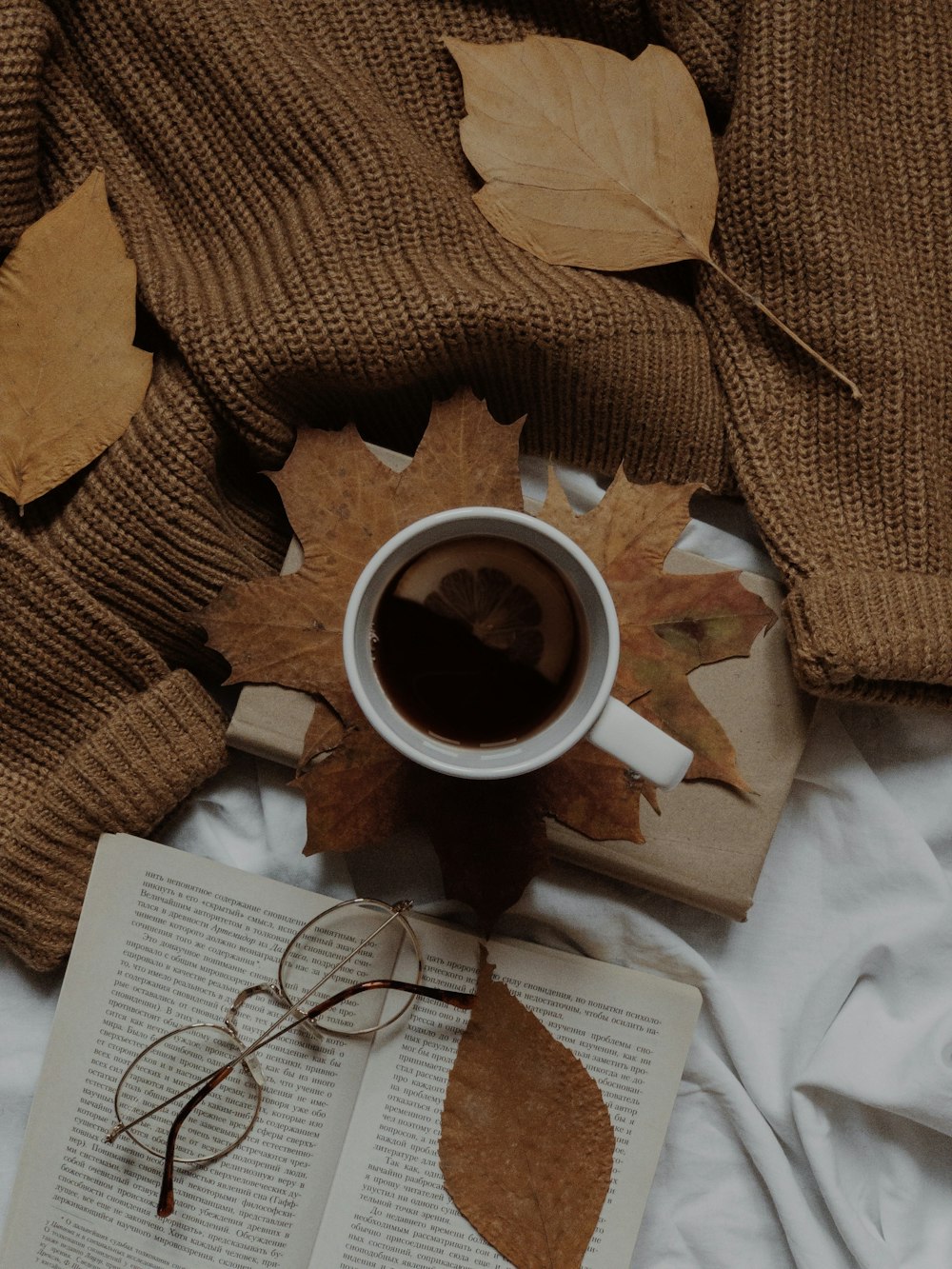 a cup of coffee and a book on a bed