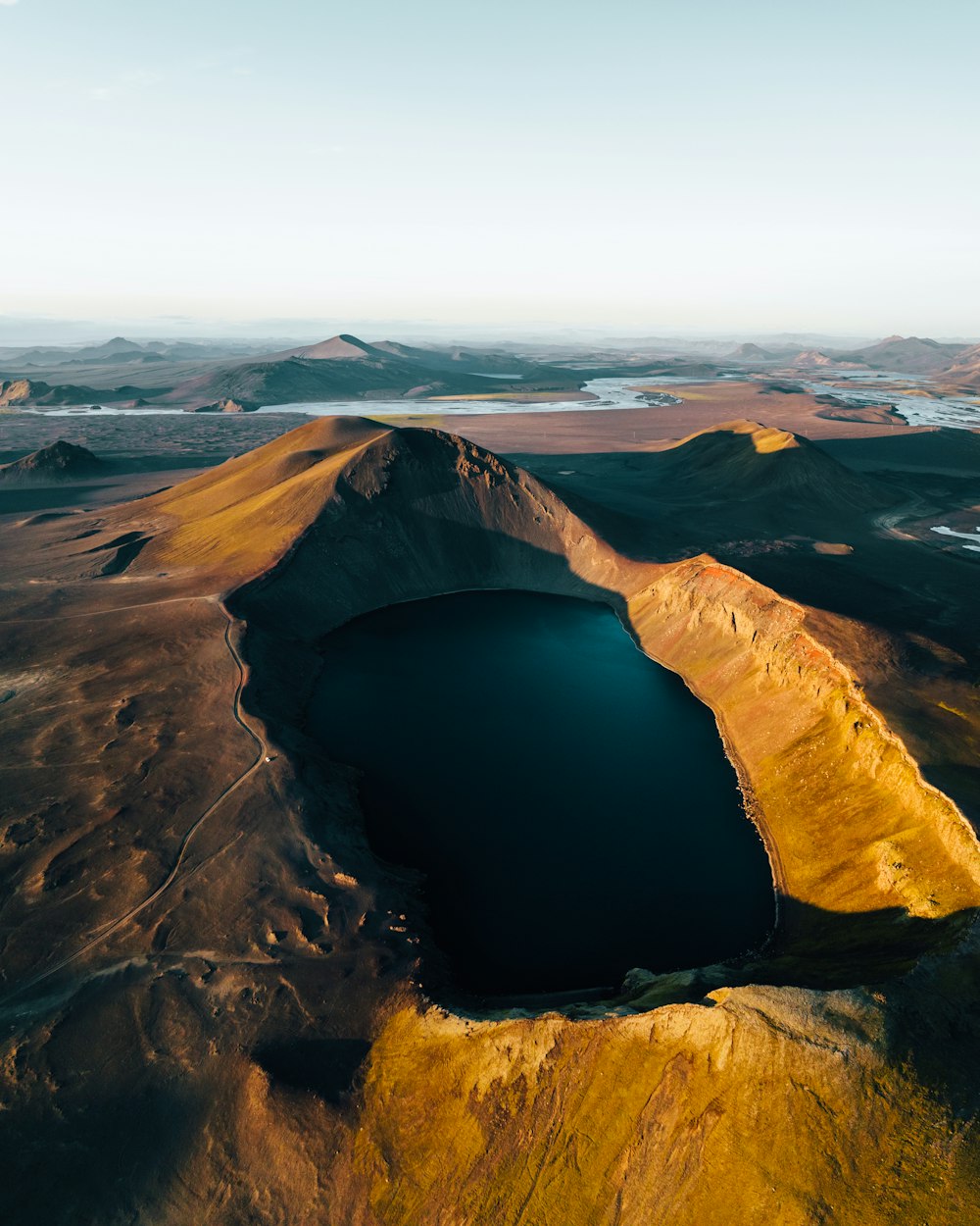 an aerial view of a lake surrounded by mountains