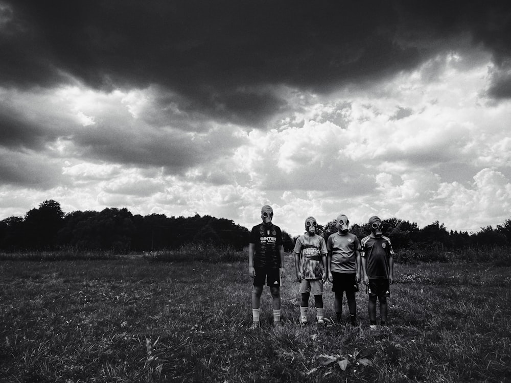 a group of people standing on top of a lush green field