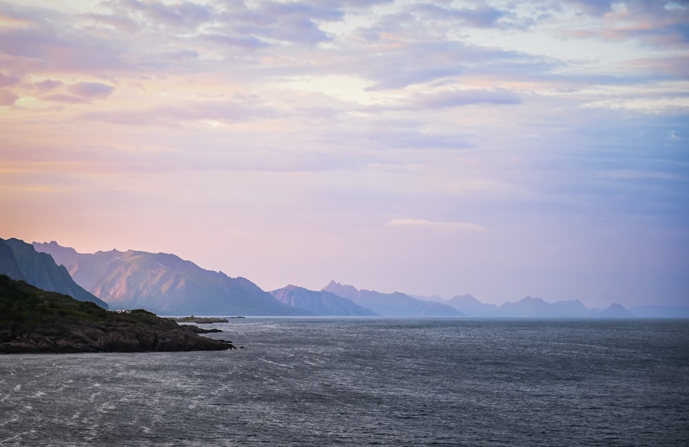 a large body of water with mountains in the background