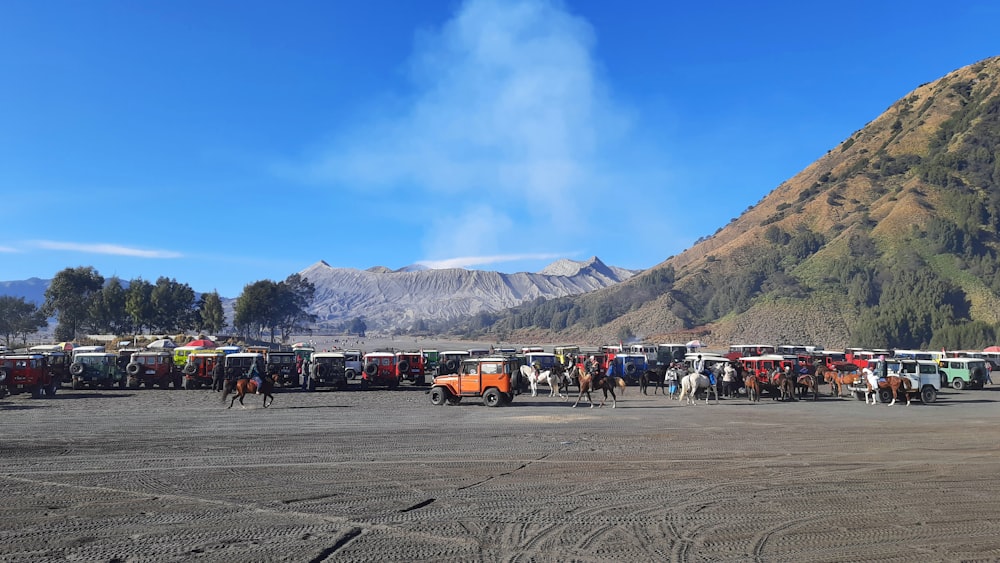 Un grupo de camiones estacionados junto a una montaña