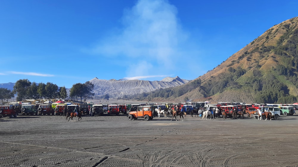 a group of trucks parked next to a mountain