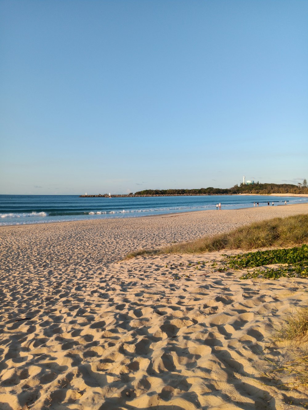 a sandy beach with waves coming in from the ocean