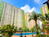 Well-maintained condominium exterior with lush landscaping and clear blue sky.