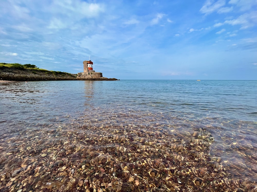 a body of water with a light house in the distance