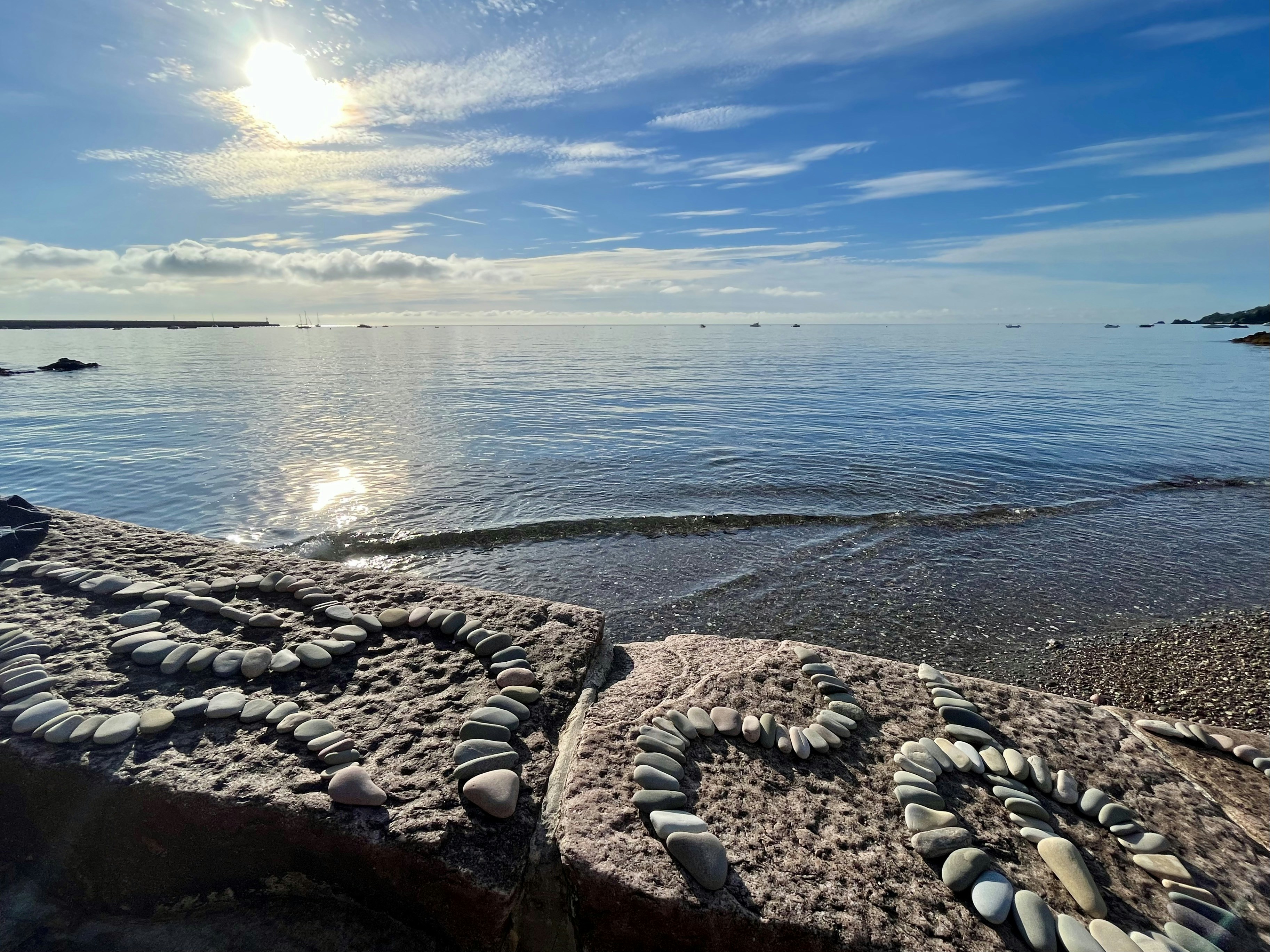 Die Sonne scheint über das Wasser und die Felsen