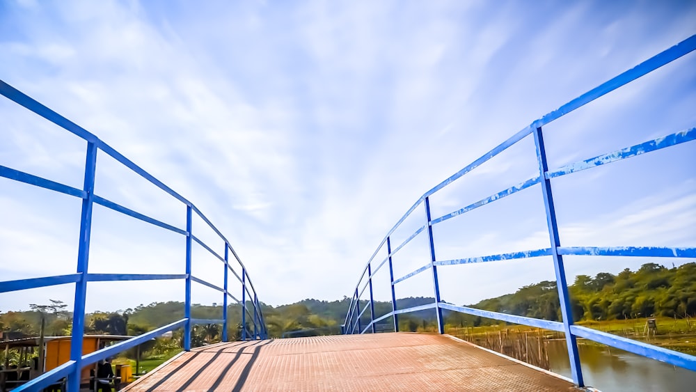 a blue metal bridge over a body of water