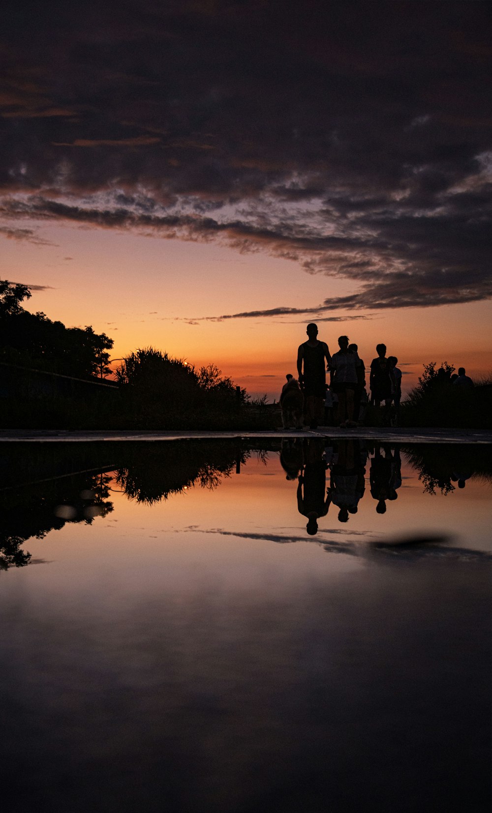 a group of people standing next to a body of water