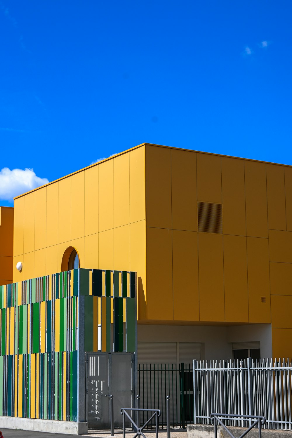 a yellow building with green and yellow stripes