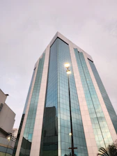 a tall glass building with a street light in front of it