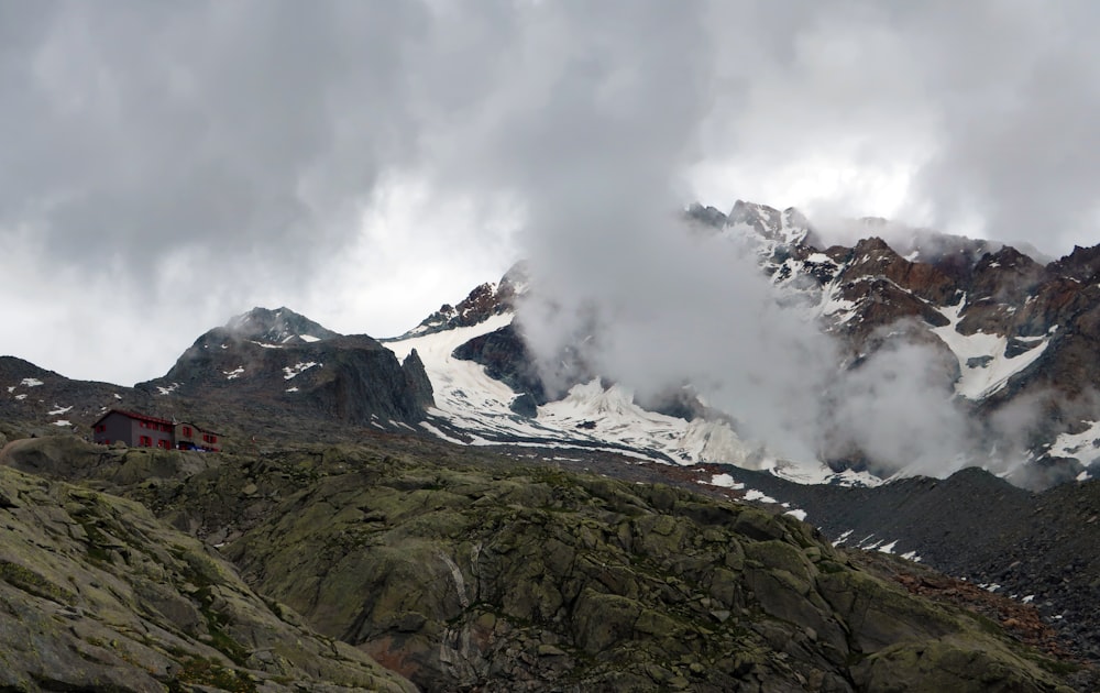 a mountain covered in snow and clouds on a cloudy day