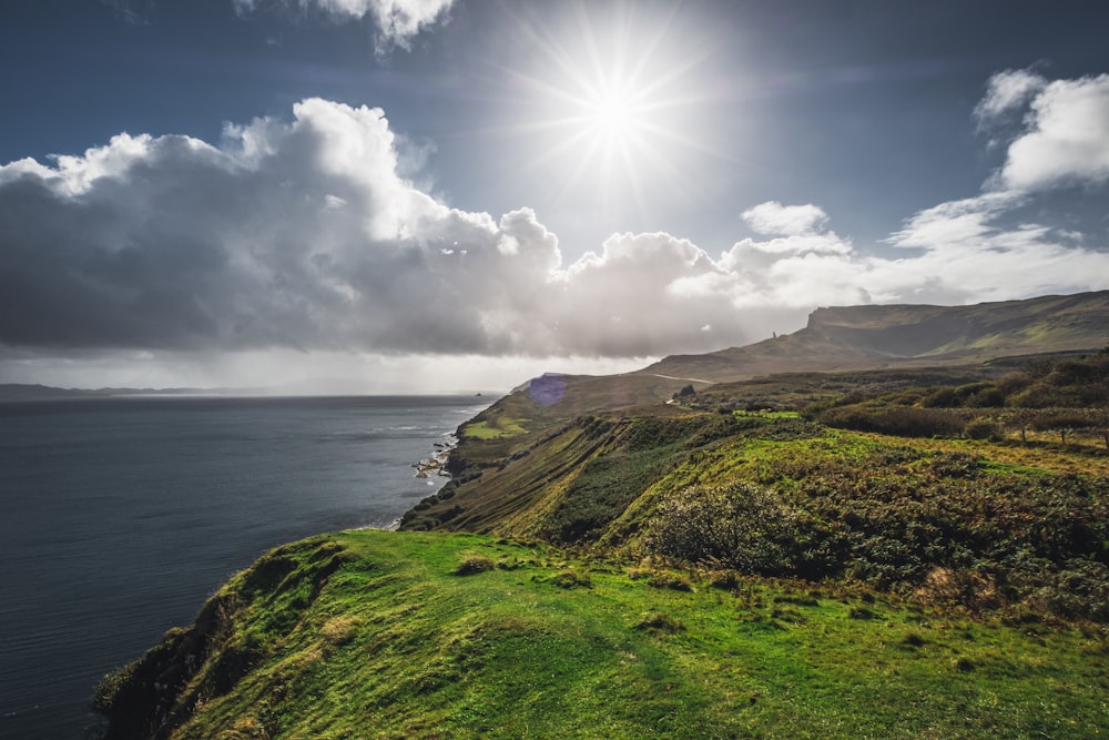 the sun shines brightly over the ocean on a cloudy day