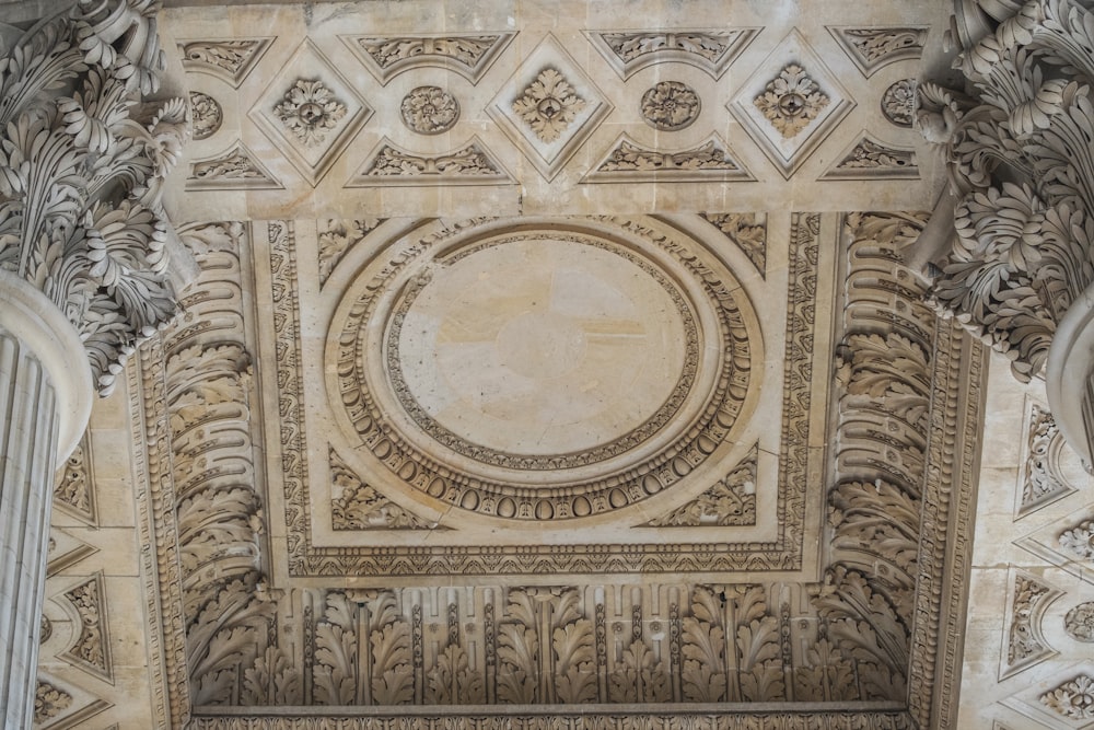 the ceiling of a building with intricate carvings
