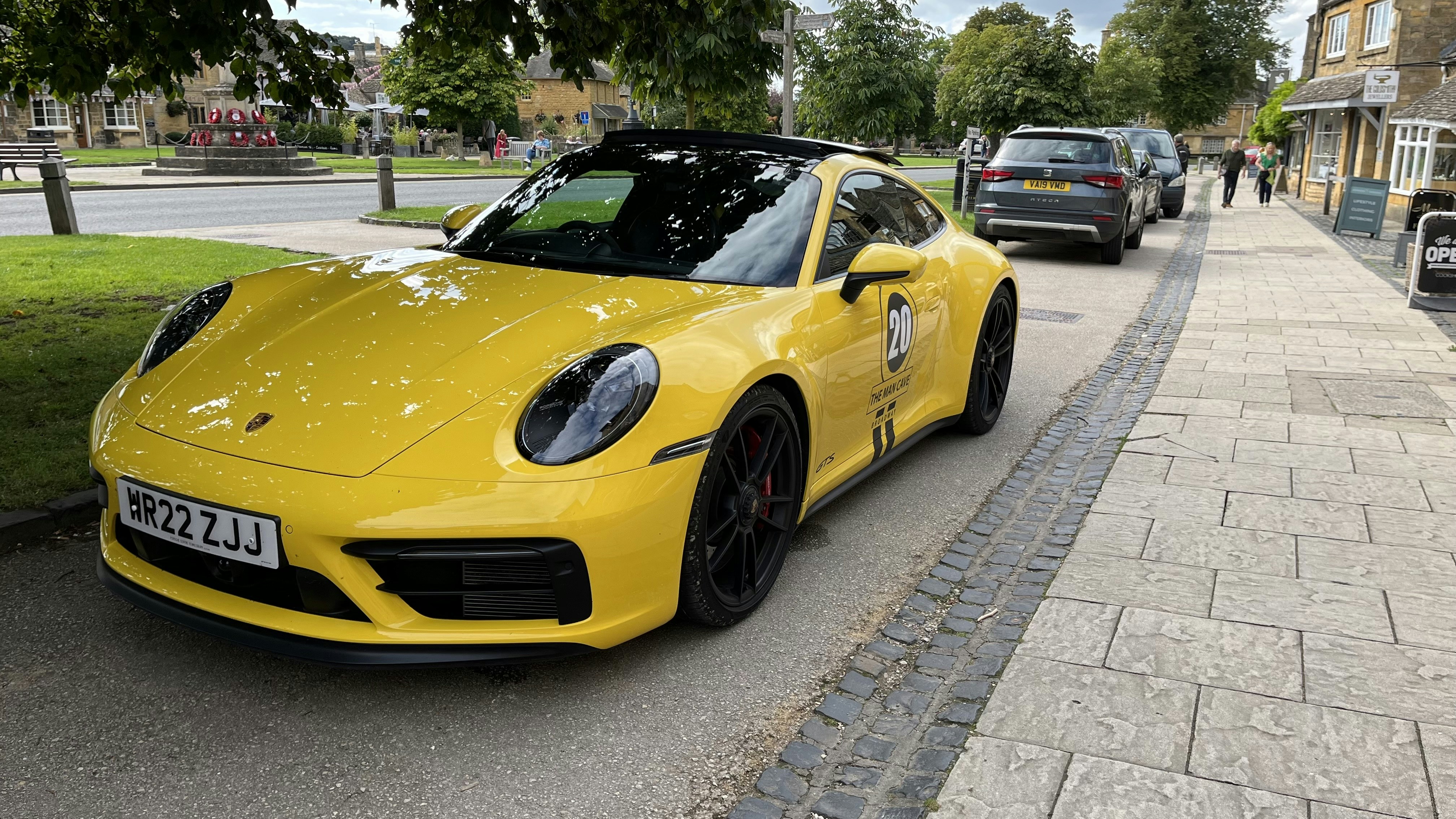 a yellow sports car parked on the side of the road