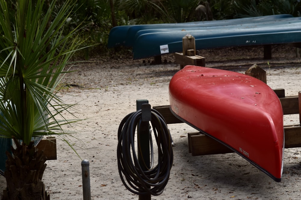 a red canoe sitting on top of a wooden bench