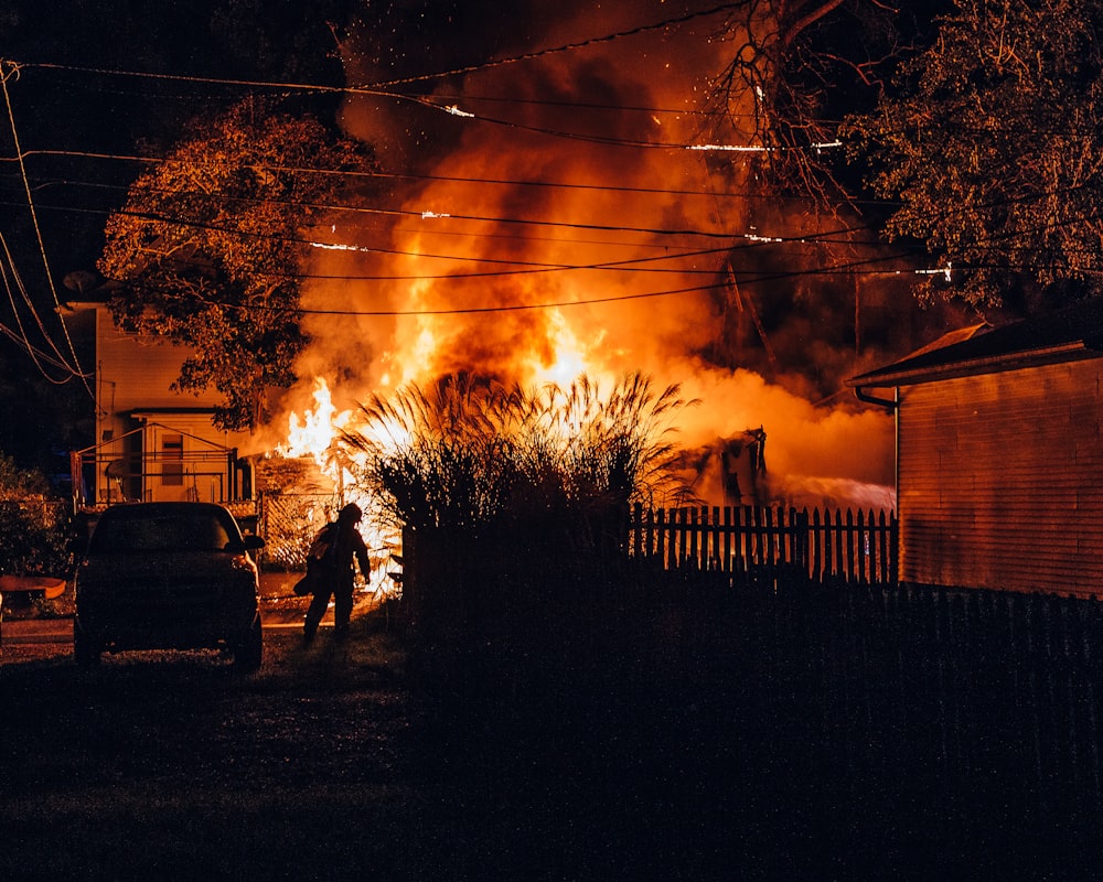 a man standing in front of a fire