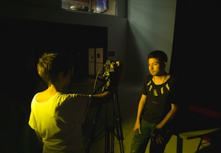 a man standing next to a woman holding a camera