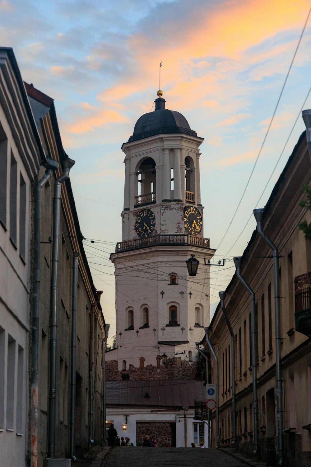 Ein hoher Glockenturm, der eine Straße in der Stadt überragt