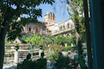 An elegant courtyard paved with reclaimed flagstone, framed by classic European architecture and lush greenery.