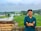 a man standing in front of a green field