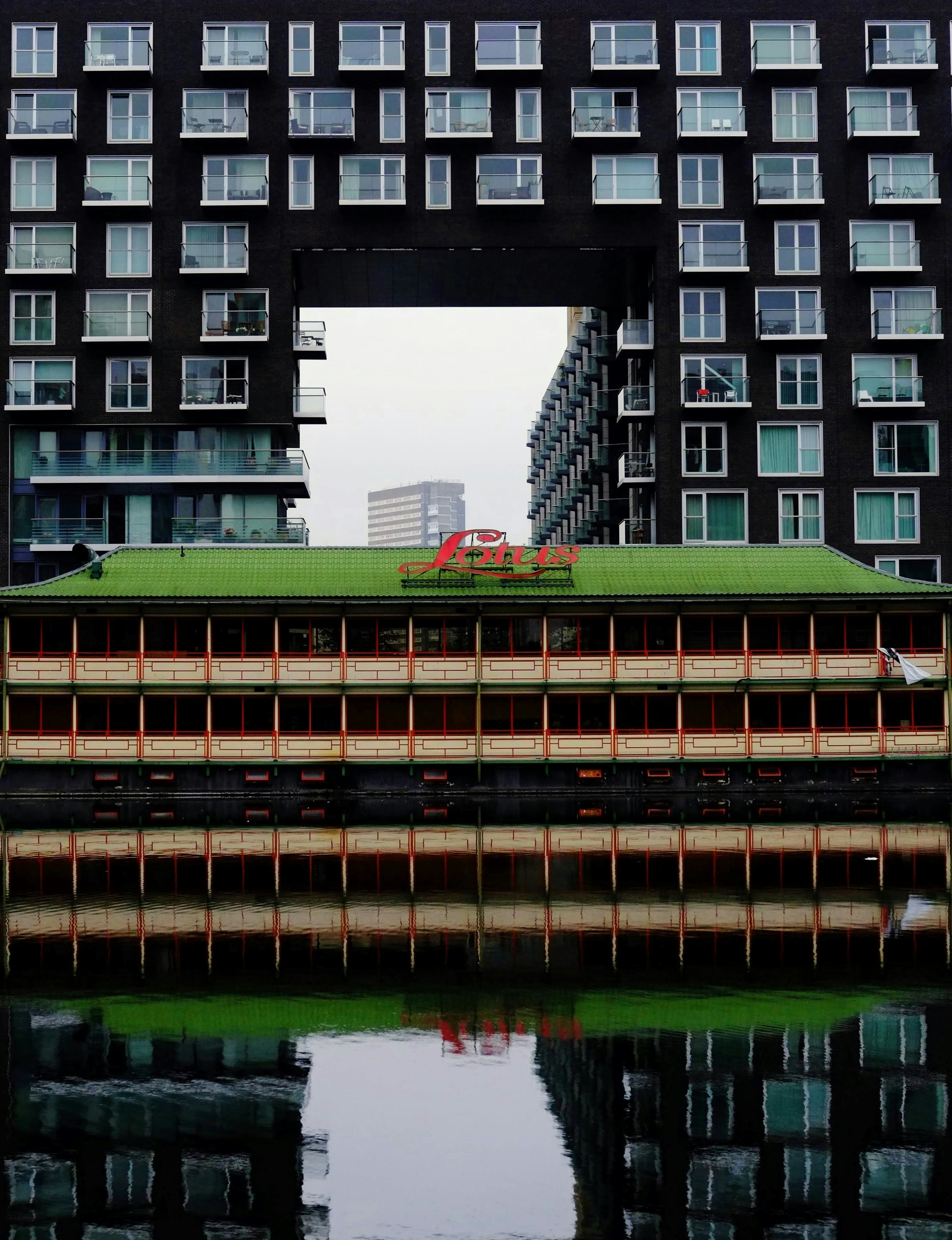 Ein großes Gebäude mit einem begrünten Dach über einem Gewässer