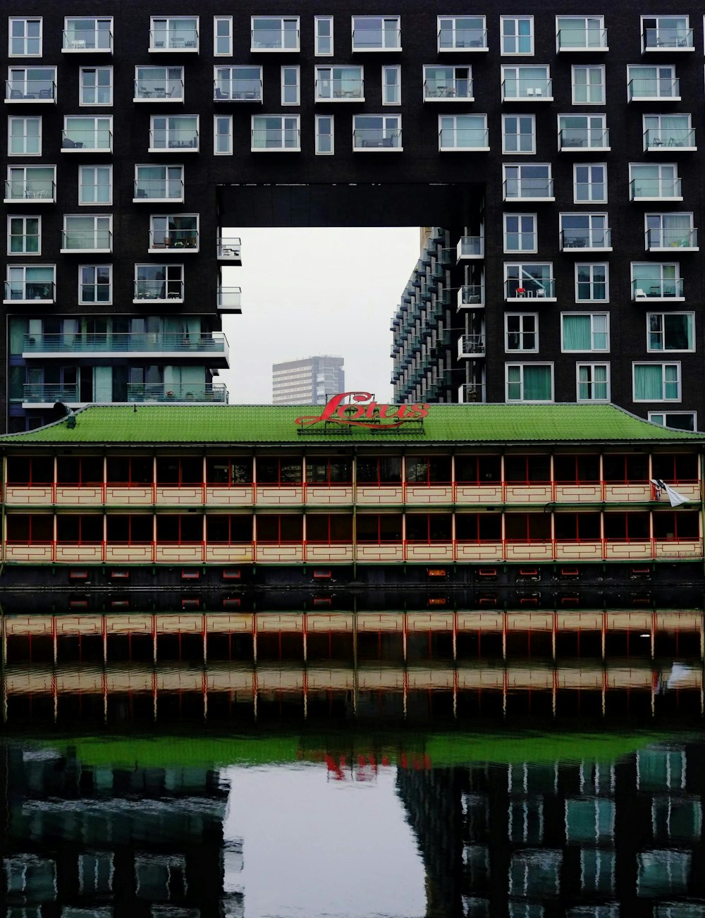 a large building with a green roof over a body of water