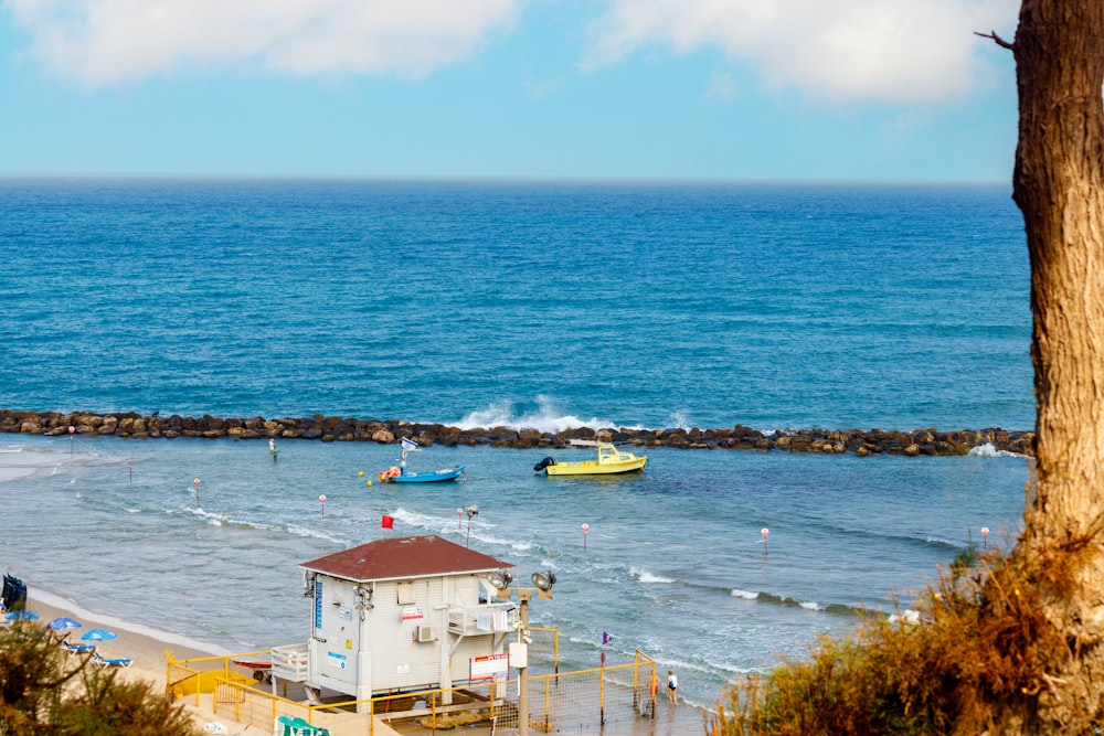 a small house sitting on top of a beach next to the ocean