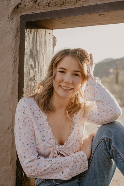 a woman sitting on the side of a building