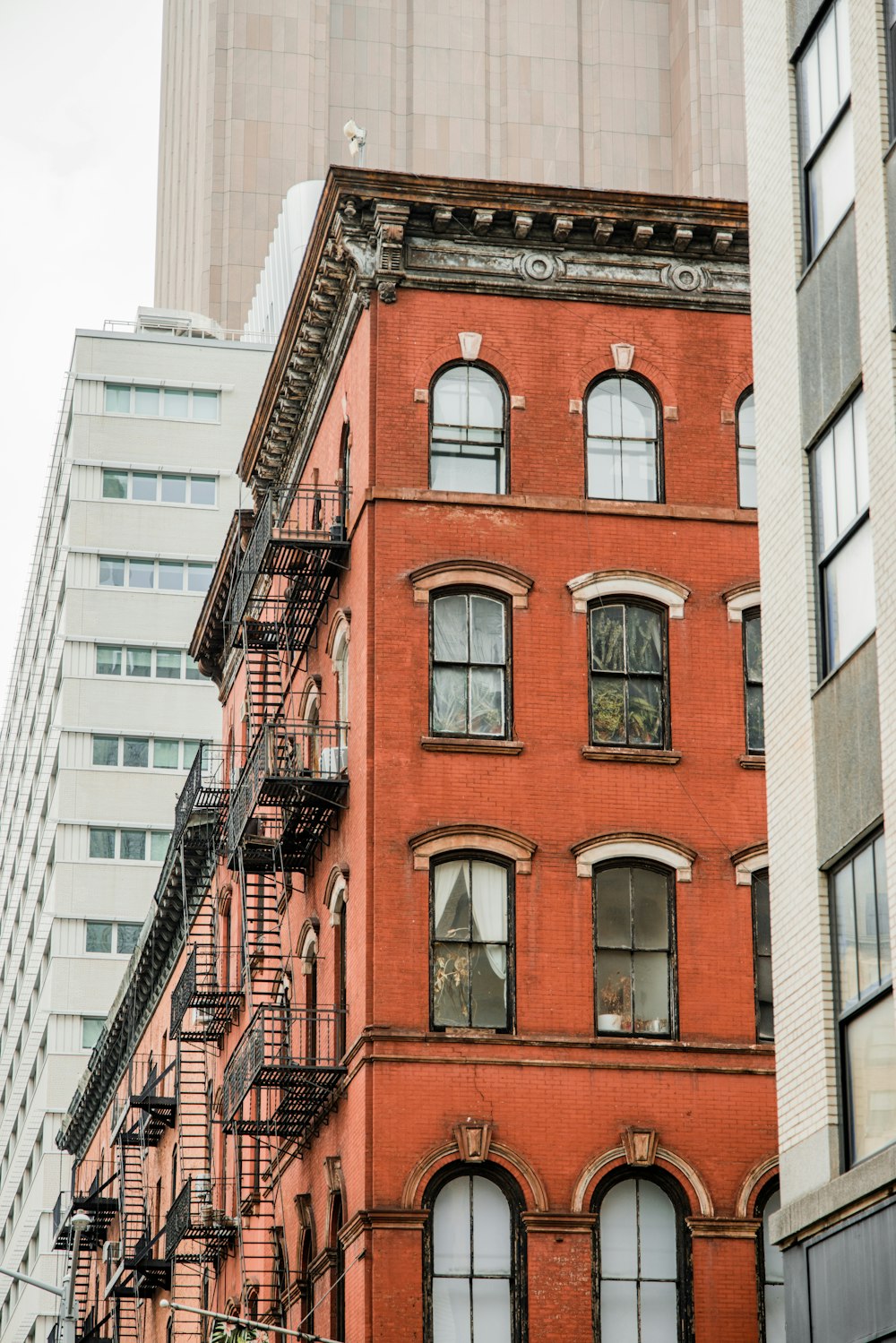 a tall red brick building with a fire escape